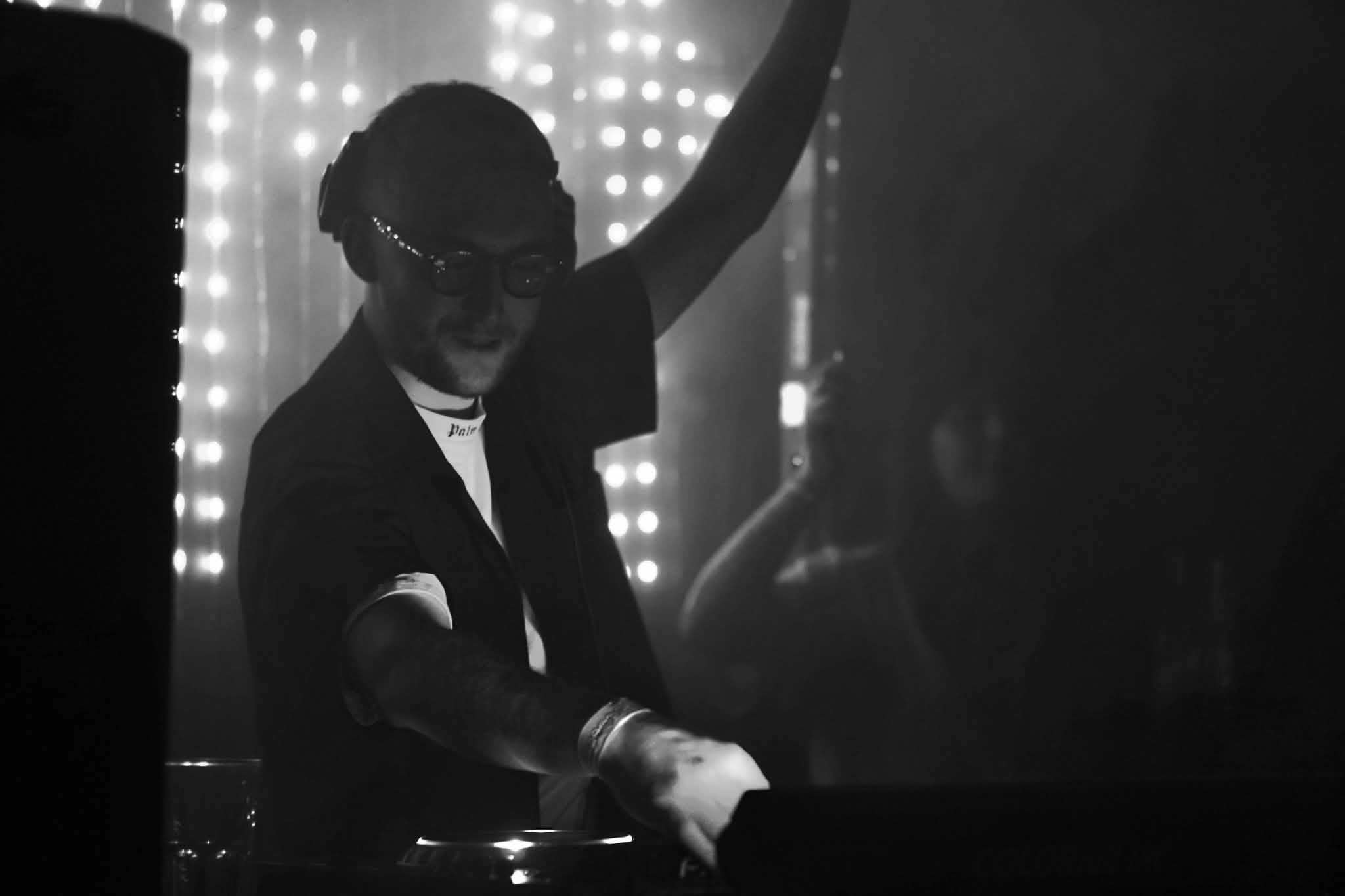 Danny Abbott performing behind the decks at a club